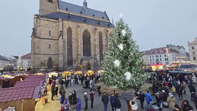 Festive Christmas market in Plzen with illuminated kiosques, holiday decorations and cathedral view on the historic main square