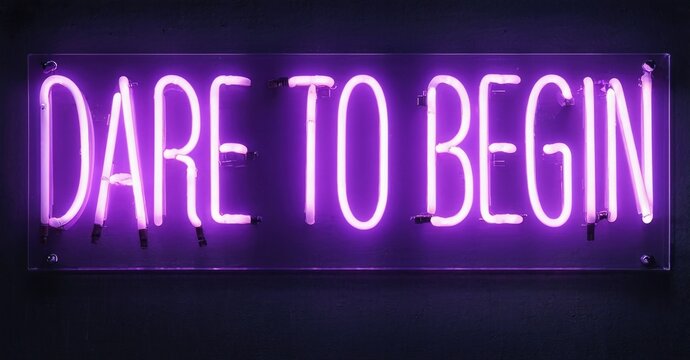 Bright purple neon sign displays words Dare To Begin against dark wall. Minimalist design, inspirational message, modern aesthetic. - Powered by Adobe