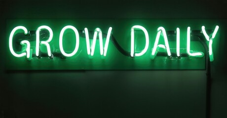 Fototapeta premium Bright green neon sign displays GROW DAILY. Wall background is dark green. Simple, motivational message, modern aesthetic.