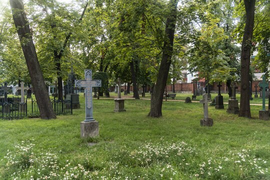 View of Alter Garnisonfriedhof cemetery with ornate tombstones and wrought-iron fences amidst lush greenery, creating a somber yet peaceful atmosphere, Mitte, Berlin, Germany.