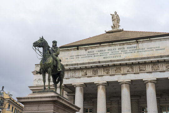 View of a bronze equestrian statue stands in stark contrast to the weathered, classical facade of the Carlo Felice opera house, under an overcast sky, Genoa, Liguria, Italy.