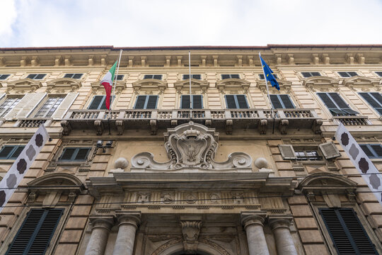 View of genoa university building facade, adorned with flags waving gently in the breeze, exhibits architectural detail, Genoa, Liguria, Italy.