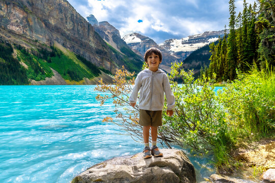 Child enjoying breathtaking view of lake louise and surrounding mountains in banff national park