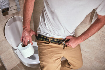 Man with urge to go to the toilet at home.