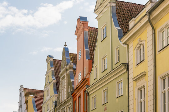 View of vibrant pastel buildings with intricate gables reach towards the sky under a soft, diffused light, a charming street scene, Stralsund, Mecklenburg-Vorpommern, Germany.