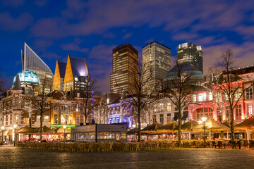 The Hague, Netherlands - 18 November 2016: View of the vibrant city skyline with its modern skyscrapers and historic buildings glowing against the twilight sky.