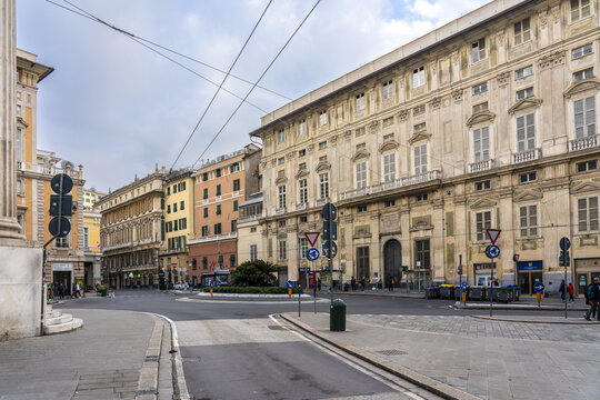 Genoa, Italy - 25 December 2022: View of the Piazza Fontane Marose, where elegant historic buildings embrace a roundabout, the grey stone streets reflecting the soft sky above.