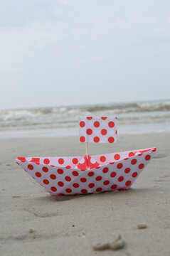 Polka dot paper boat on sandy beach at Amrum North Sea Germany