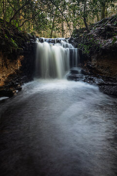 Fast flowing waterfall after December rainfall in Ashdown forest on the high weald east Sussex south east England UK