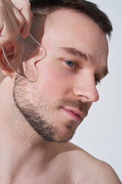 Portrait of man practicing facial self-care with gua sha tool