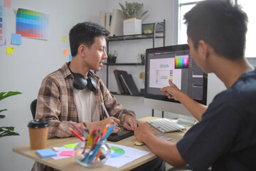 Graphic Designers Collaborate on Logo and Design Concept on Desktop Compute