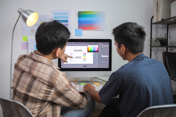 Two Graphic Designers Collaboratively Working on Logo and Color Palette Selection Using Computer