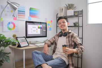 Designer Working at Computer in Home Office Holding Color Fan Decks to Choose