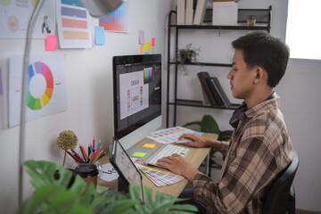 Side View of Creative Man Working on Branding Project With Color Palettes and Inspiration Boards