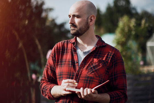 Person writing on red pad in London allotment garden outdoors