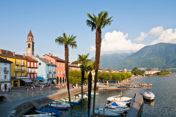 Colorful waterfront with boats and palm trees in Ascona on Lake Maggiore