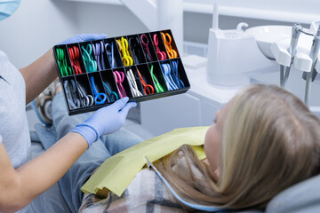 Child choosing colorful braces bands during pediatric dental visit in modern clinic