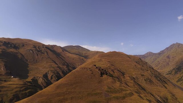 Aerial view of the Kvavlo village under the clear sky, showcasing the rugged terrain and natural beauty of the landscape, Dartlo, Tusheti, Georgia.