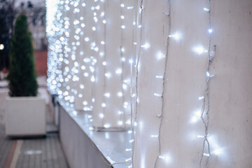 Winter outdoor walkway with string lights along a building wall.