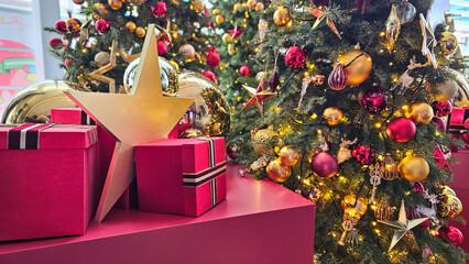 Warm and joyful Christmas holiday decoration featuring beautifully adorned Christmas trees with colorful ornaments, golden hanging decor, stars, red gift boxes, pine needles and festive greenery, crea