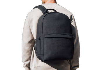 A person wearing a black backpack outdoors with sunlight