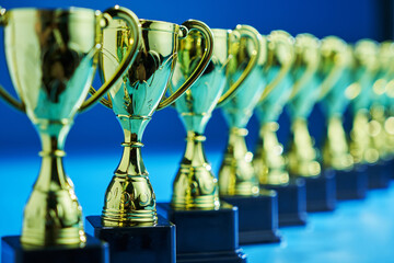 group of trophies in a row against blue background