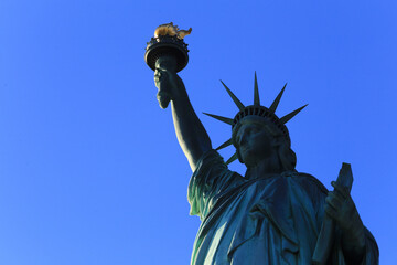 The Statue of Liberty's Majestic Torch and Crown Against a Clear Blue Sky: An Iconic Symbol of Freedom in New York City, USA