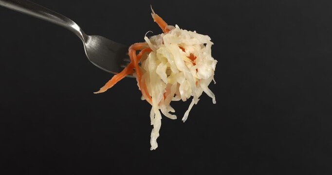 Fork with fermented cabbage with carrots, sauerkraut, sauer kraut, a healthy vegan crunchy probiotic.