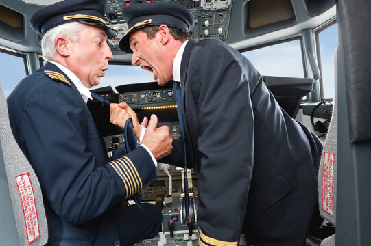 Pilots arguing aggressively in airplane cockpit during flight