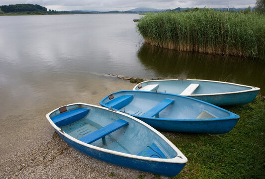 Blue fishing boats moored at the shore of Wallersee lake Austria