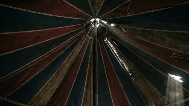 Inside view of striped circus tent big top. Traditional entertainment venue with red blue canvas roof and spotlights. Performance space for shows and crowds.
