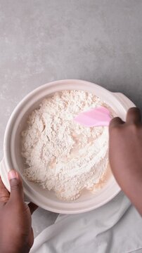 overhead view of focaccia dough being mixed in a claypot, top view of a high hydration focaccia bread dough in a donabe, process of making high hydration focaccia