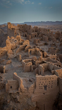 Aerial view of crumbling, sun-baked structures cascade down the arid landscape, revealing the ancient ruins, Isfahan, Isfahan Province, Iran.