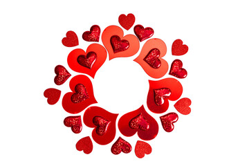Red heart shape cutouts and glitter hearts arranged in a circular frame. Love and romance concept for Valentines Day or wedding invitation design.