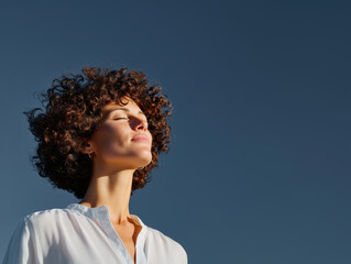 Woman enjoying sun eyes closed taking deep breath