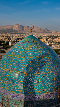 Aerial view of the mesmerizing turquoise dome of the Imam Mosque, adorned with intricate floral patterns under the clear sky, Isfahan, Giza Governorate, Egypt.