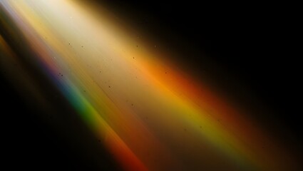 A striking diagonal light ray with a vibrant rainbow spectrum and floating dust particles on a black background