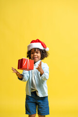 Obraz premium Happy child celebrating the holiday season, catching his red present