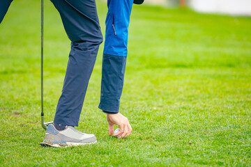 Golfer's hand placing ball on a golf tee