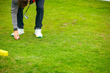 Golfer's hand placing ball on a golf tee