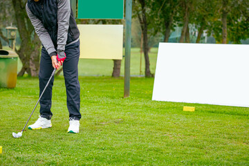 Golfer performs a strong golf shot to fairway