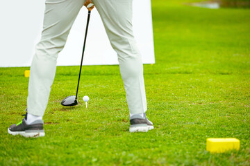 Golfer performs a strong golf shot to fairway