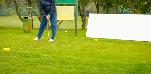 Golfer performs a strong golf shot to fairway