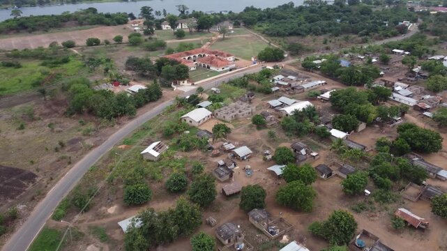 Aerial drone footage of Ghana, Africa, serene lake, rolling mountains and natural landscape. Boats on the water. A local village, near the Right to Dream Football Academy.