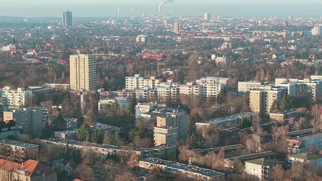 Tilted drone fly at dense urban housing blocks with Berlin capital city skyline, Germany