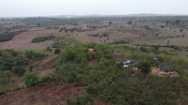 Aerial drone footage of Ghana, Africa, serene lake, rolling mountains and natural landscape. Boats on the water. A local village, near the Right to Dream Football Academy.
