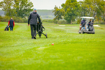 People, golfers enjoying on the golf course, playing together