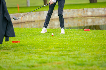 Golfer performs a strong golf shot to fairway