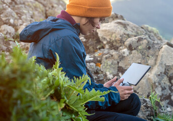 A girl travels and flights a drone, holds a remote control in her hands.