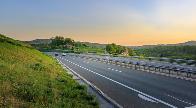 Long road with a grassy hillside on the side